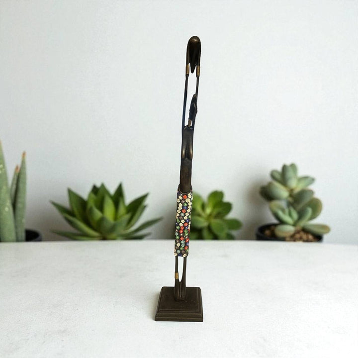 Decorative brooch on a stand with succulents in the background