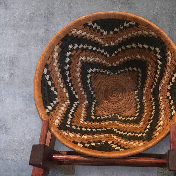 Woven basket with concentric circle pattern on a gray background