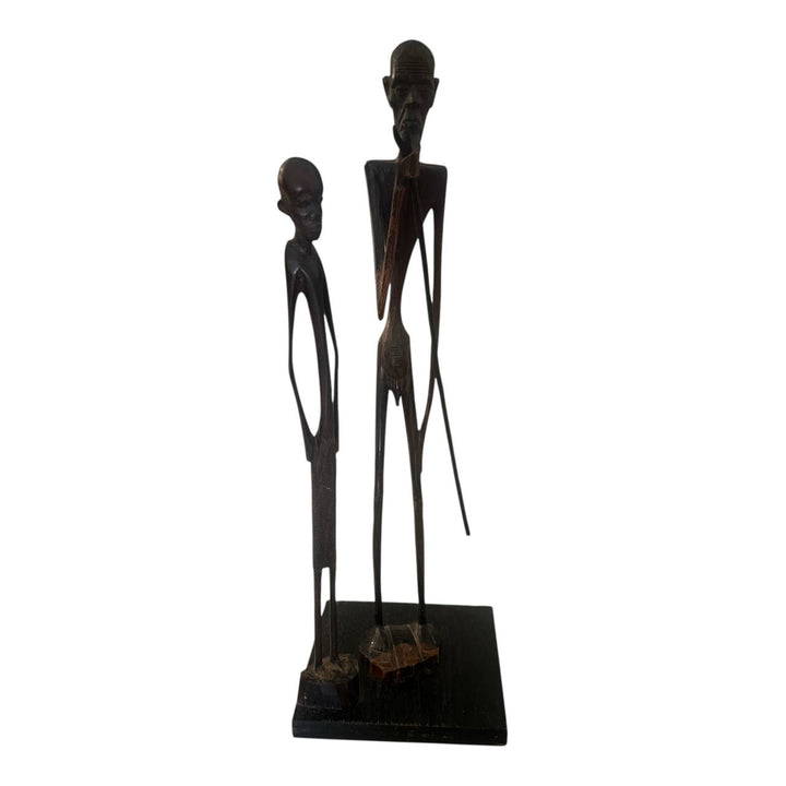 Black silhouette of two standing figures on a white background