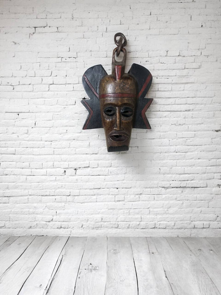 Wooden mask on a white brick wall