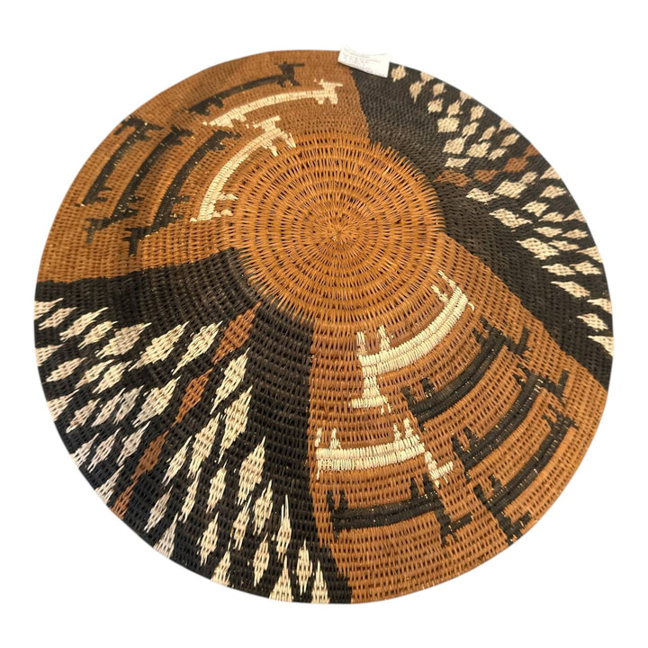 Decorative woven basket with circular pattern on a white background