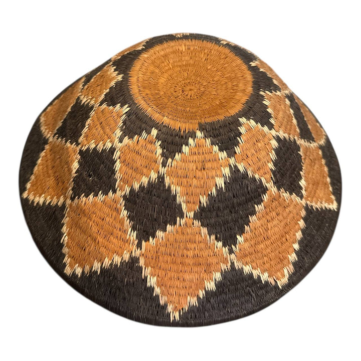 Round woven mat with brown and black diamond pattern on a white background