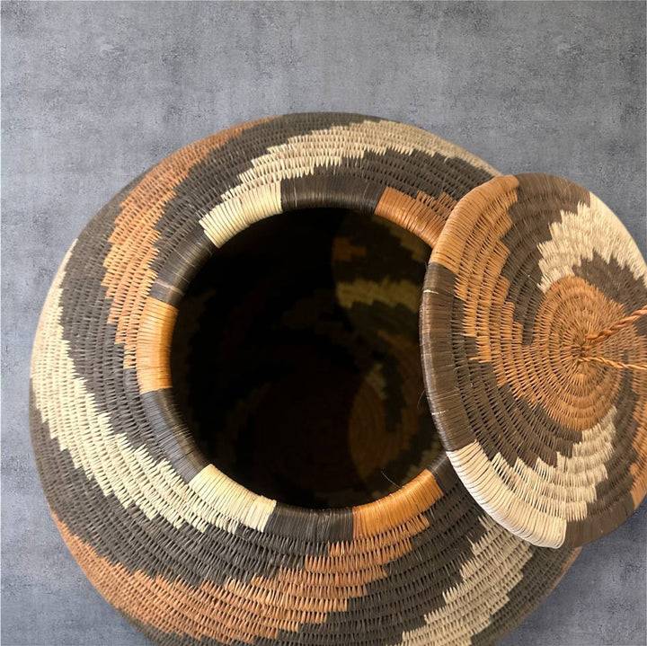Woven basket with a lid on a gray background