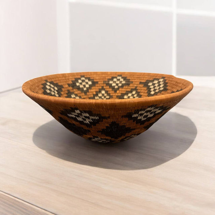 Woven basket with geometric pattern on a wooden surface