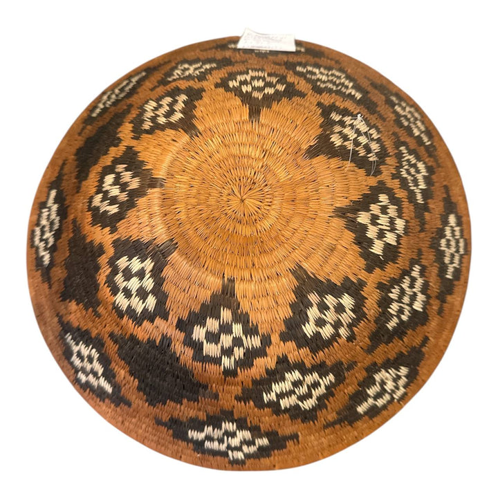 Decorative woven basket with geometric pattern on a white background