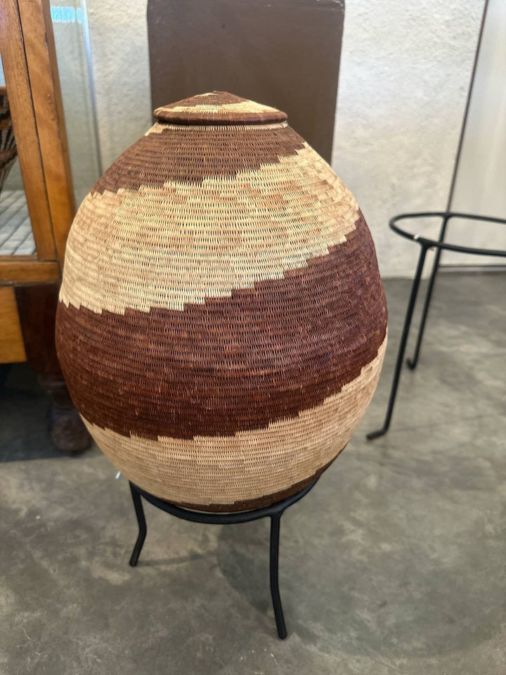 Woven basket on a stand with a textured background