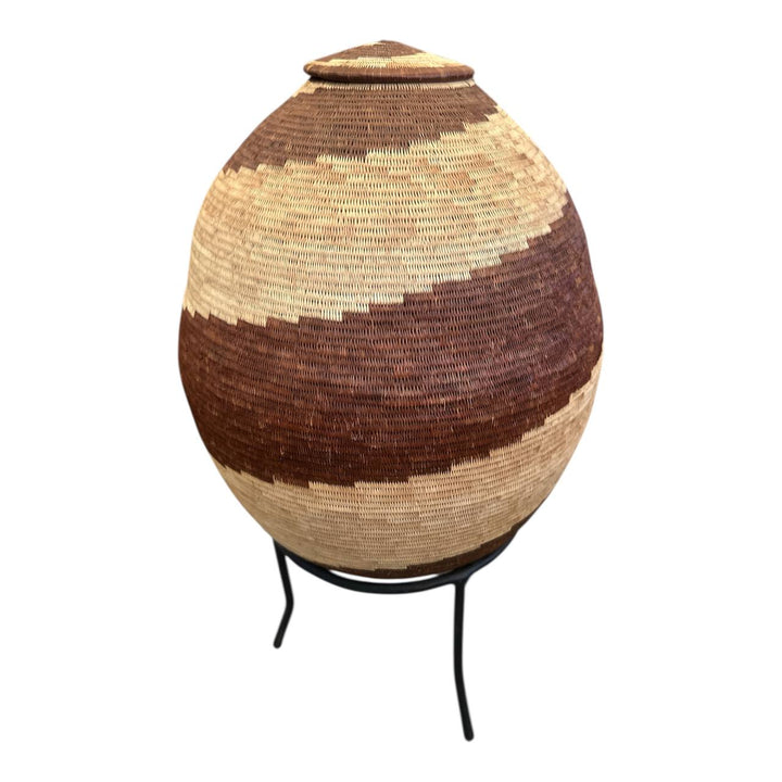 Woven basket with a lid on a stand against a white background