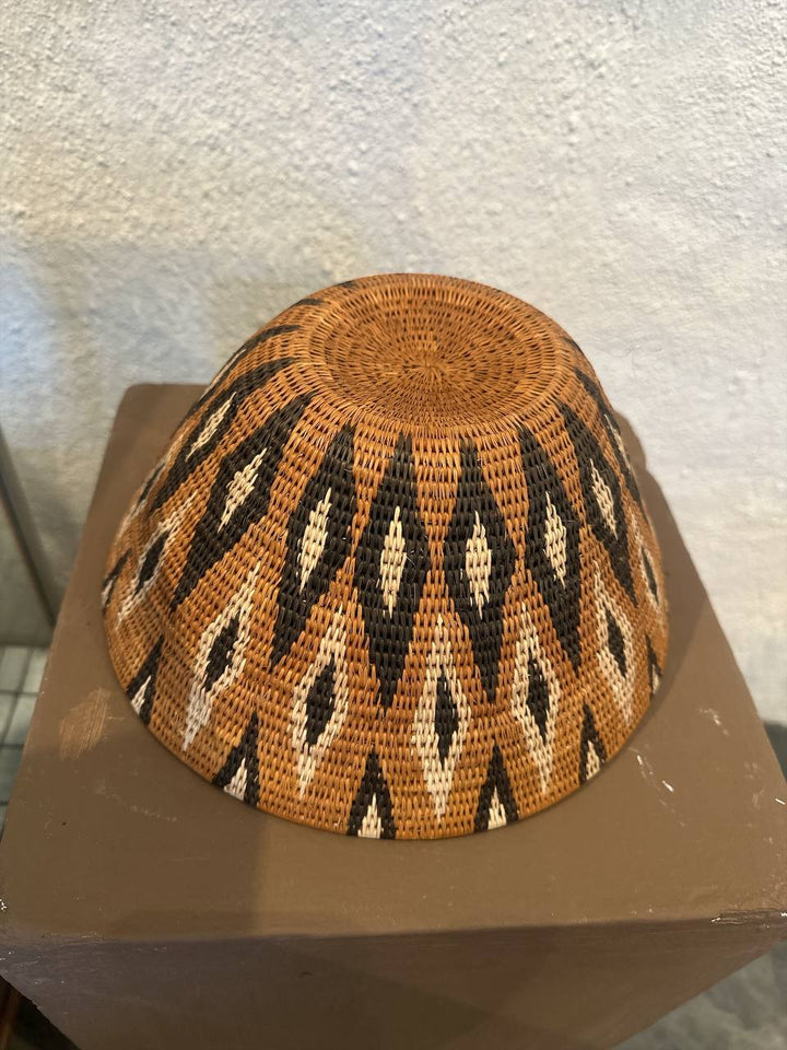 Woven basket with a geometric pattern on a textured surface
