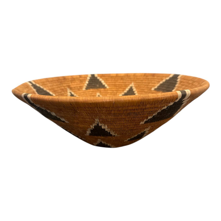 Woven basket with geometric pattern on a white background